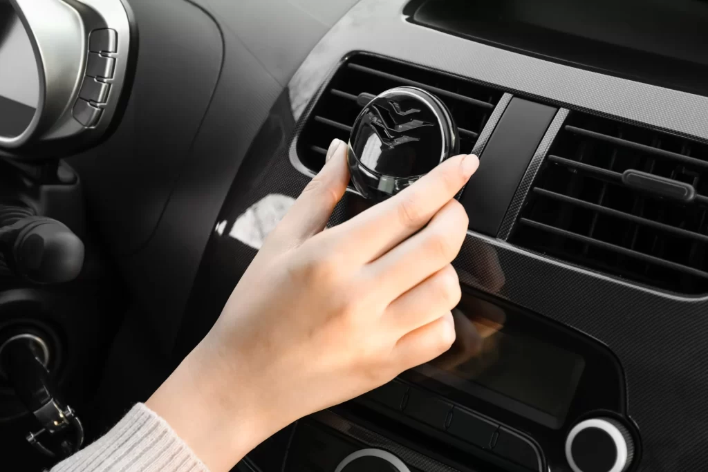 Female,Hand,With,Air,Freshener,Hanging,In,Car,,Closeup - SportDeník Žena nastavuje v autě vonnou esenci