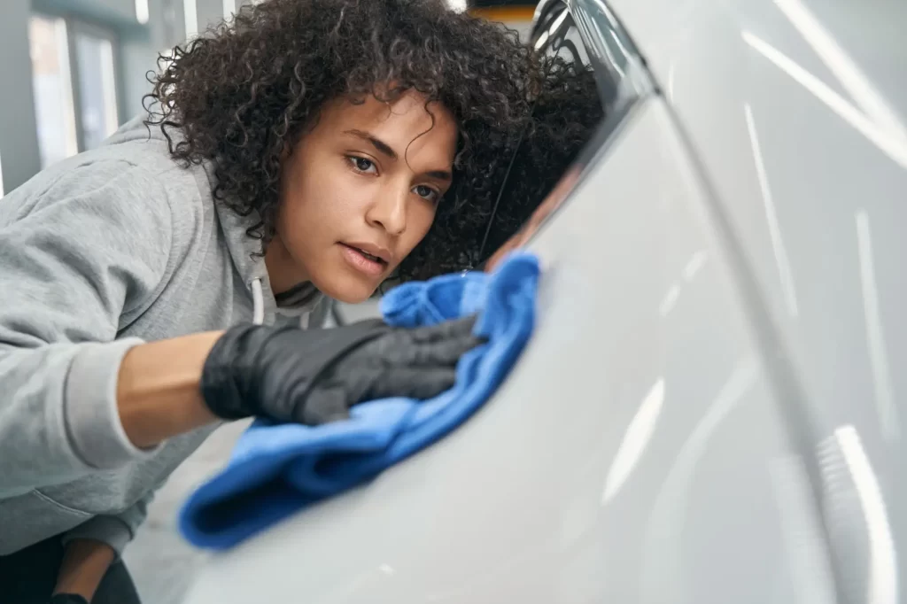 mikropenis - SportDeník soustředěná žena leští auto hadříkem z mikrovláken