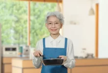 japonská žena ve vysokém věku s úsměvem připravuje pokrm