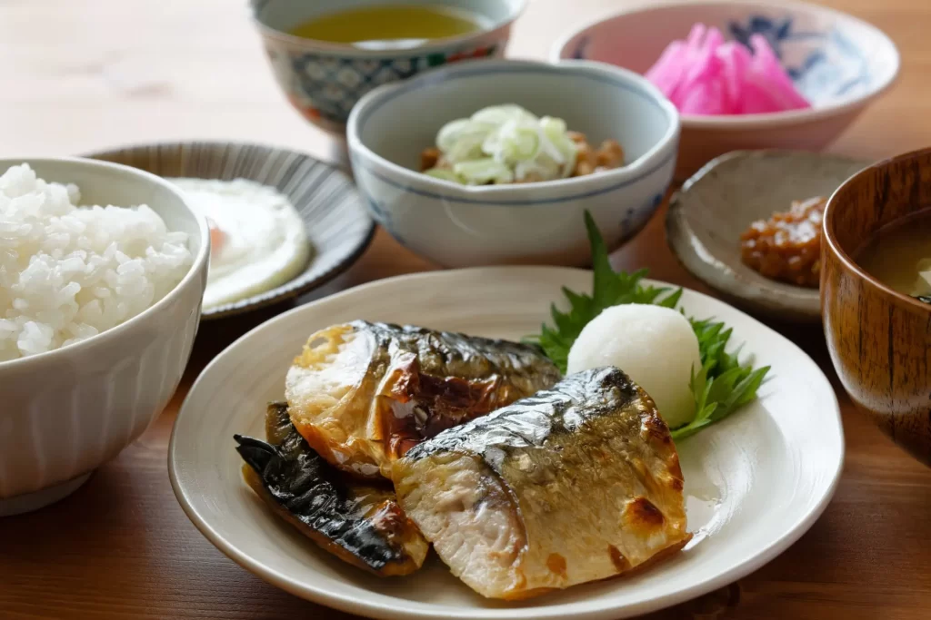 papu - SportDeník stůl plný japonského jídla, obsahujícího ryby a rýži