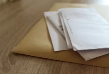 štos neotevřených obálek na stole
