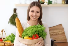 Žena držící tašku se zeleninou.