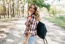 Mladá žena na vycházce v přírodě. Usmívá se.