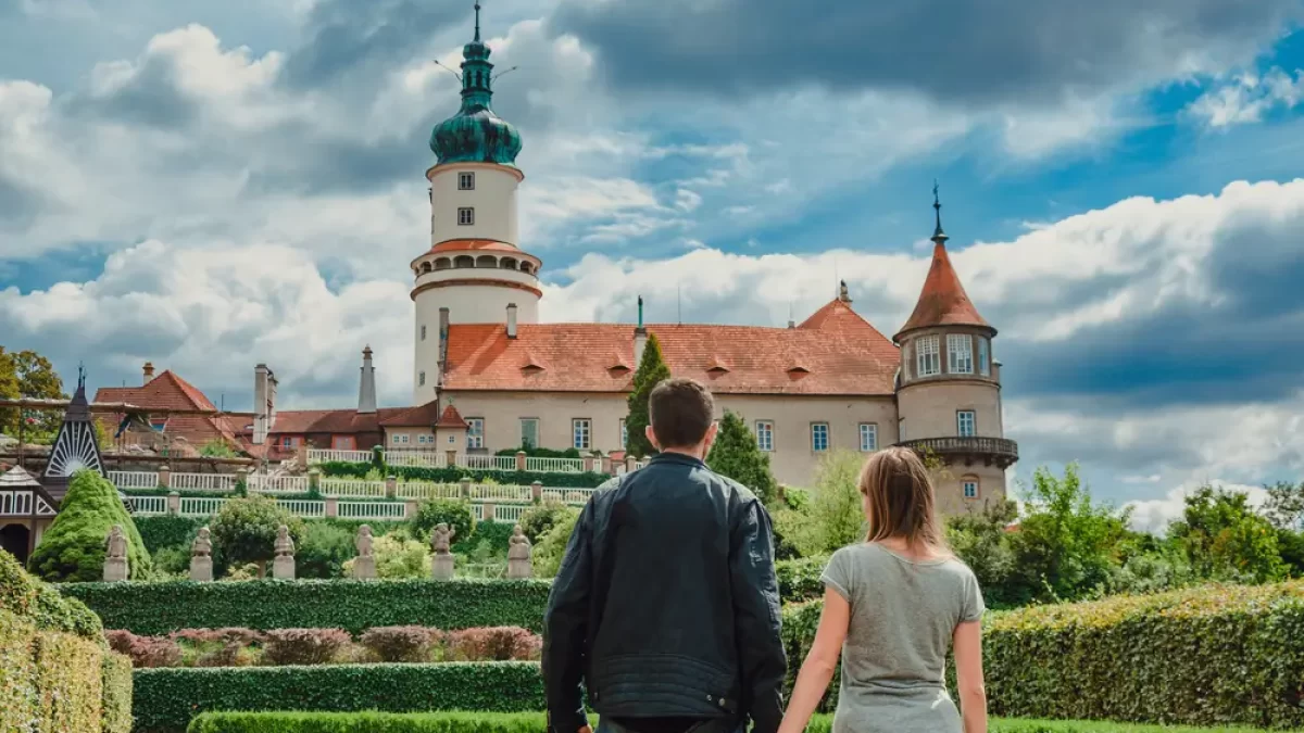 Zámek v Novém Městě nad Metují za bílého dne. Na fotce se nachází muž a žena, kteří se drží za ruce.