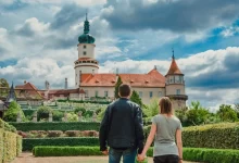 Zámek v Novém Městě nad Metují za bílého dne. Na fotce se nachází muž a žena, kteří se drží za ruce.