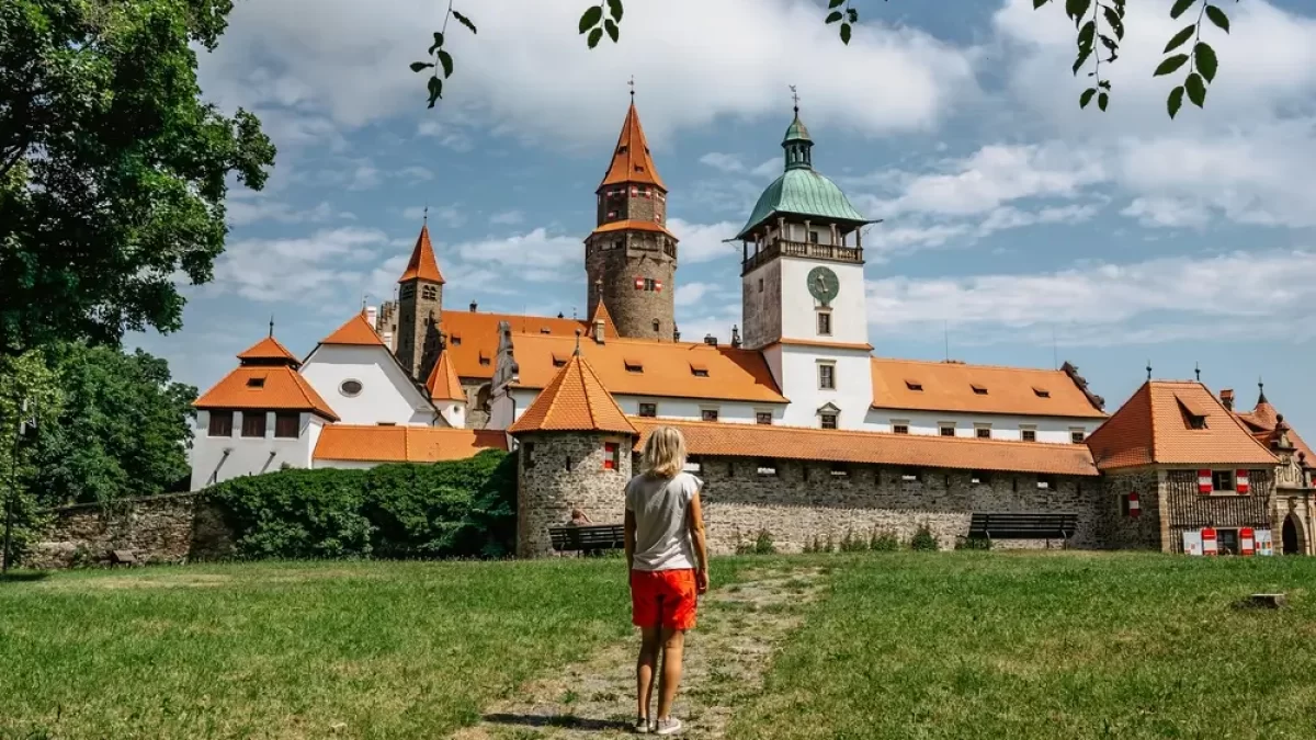 Žena kráčí směrem k hradu Bouzov.