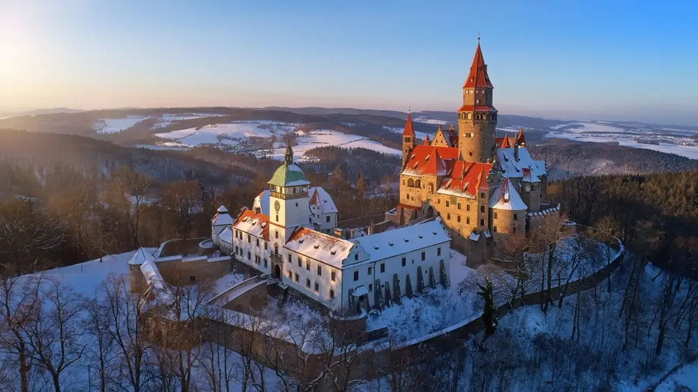 shutterstock_2272379543 - SportDeník Hrad Bouzov z leteckého pohledu. Okolní krajina je zasypaná sněhem.