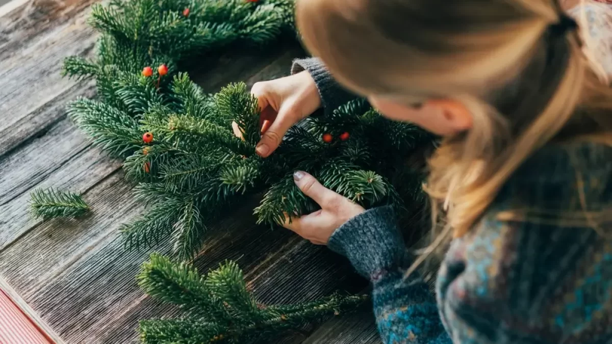 Žena vyrábějící adventní věnec