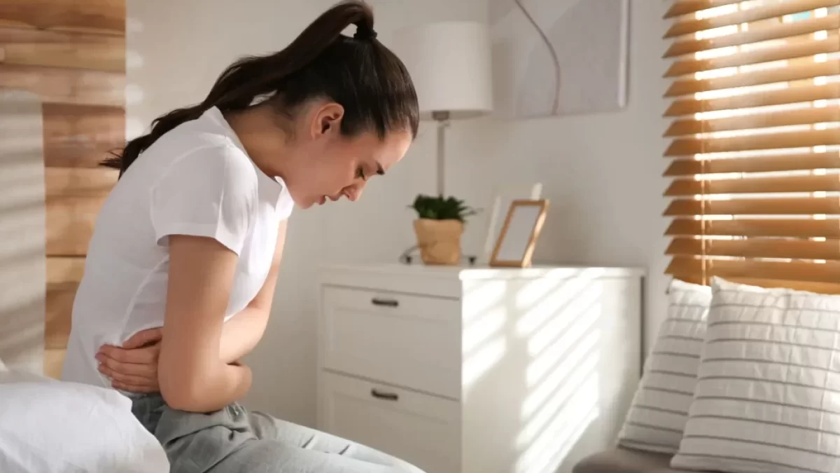 žena v bolestech se drží za břicho