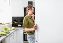 žena přemýšlí při pohledu do mrazáku