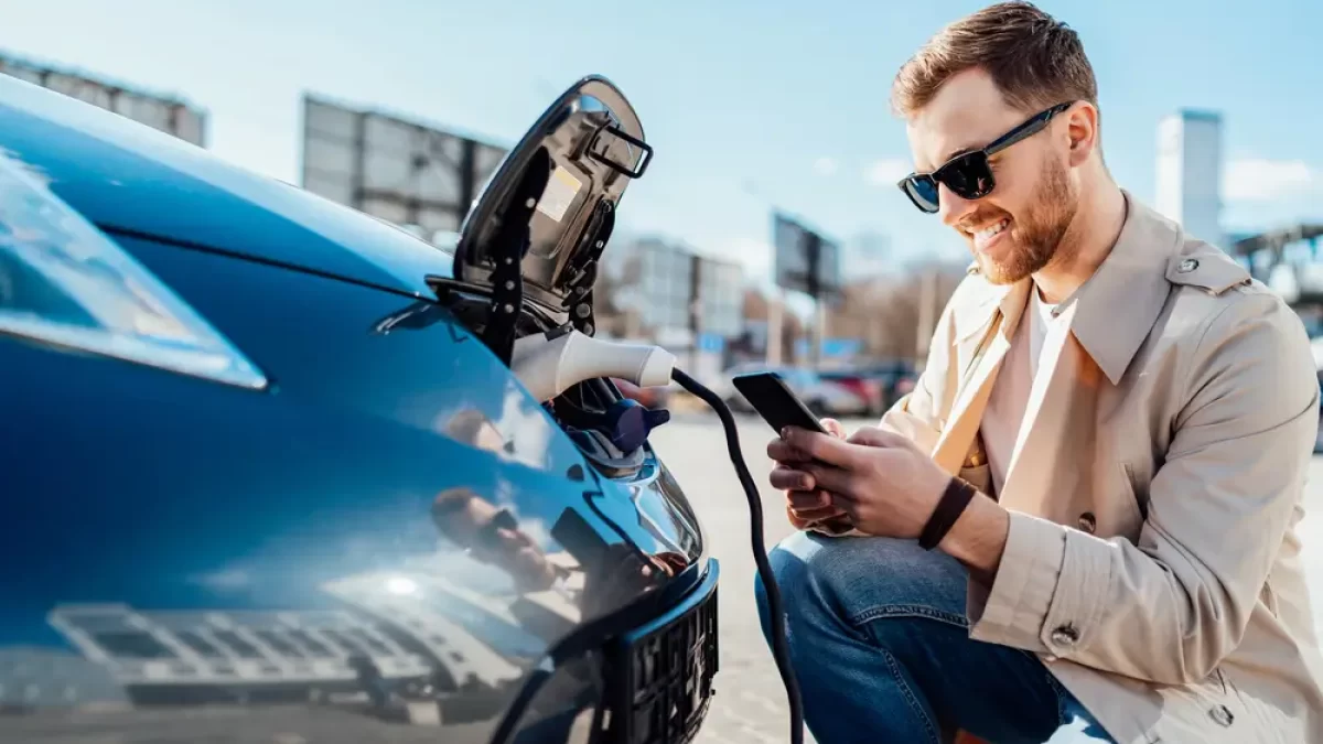 Muž dobíjející elektromobil