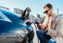 Muž dobíjející elektromobil