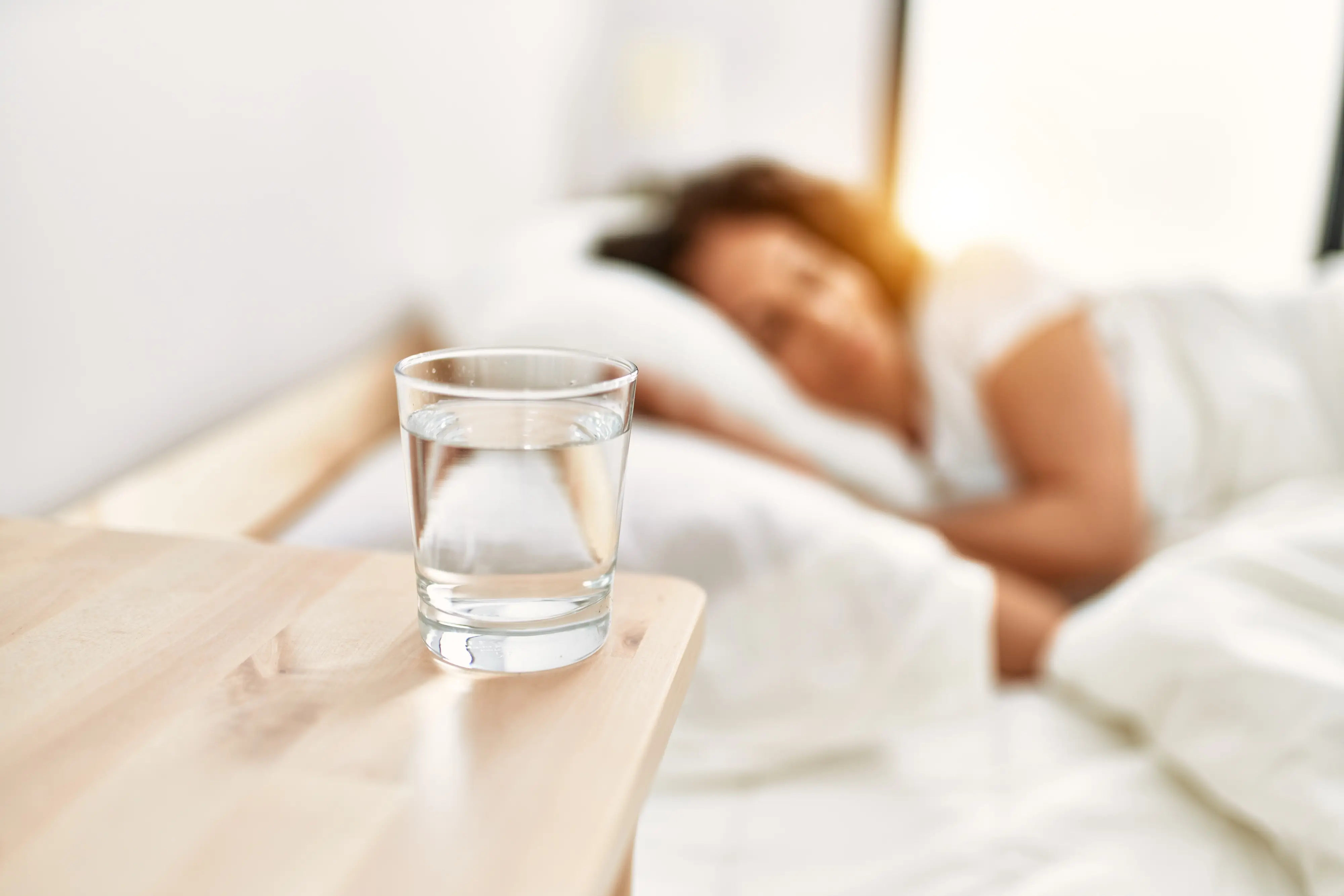 sklenice vody na nočním stolku