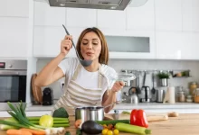 žena ochutnává jídlo z hrnce