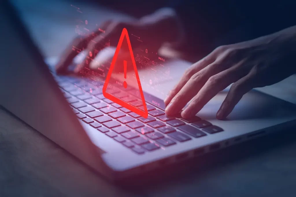 Phishing 2 2 - SportDeník Ruce na klávesnici PC s varujícím červeným vykřičníkem