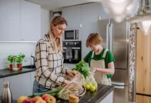 Žena a dítě v kuchyni vybalují zeleninu