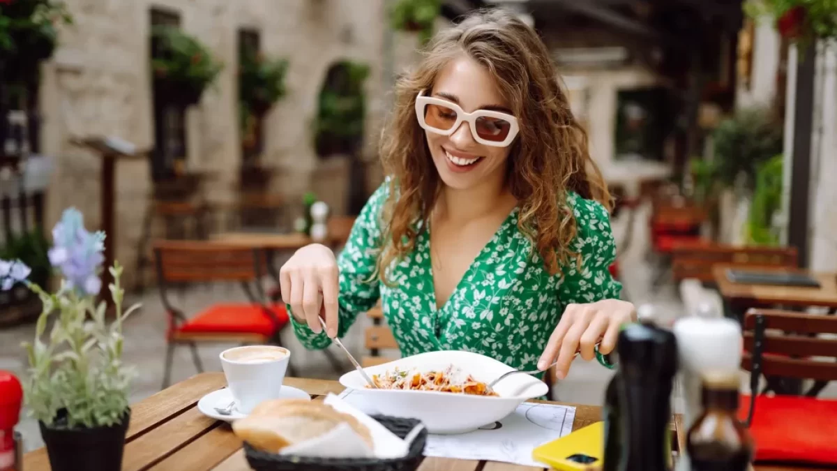 žena jí jídlo v restauraci