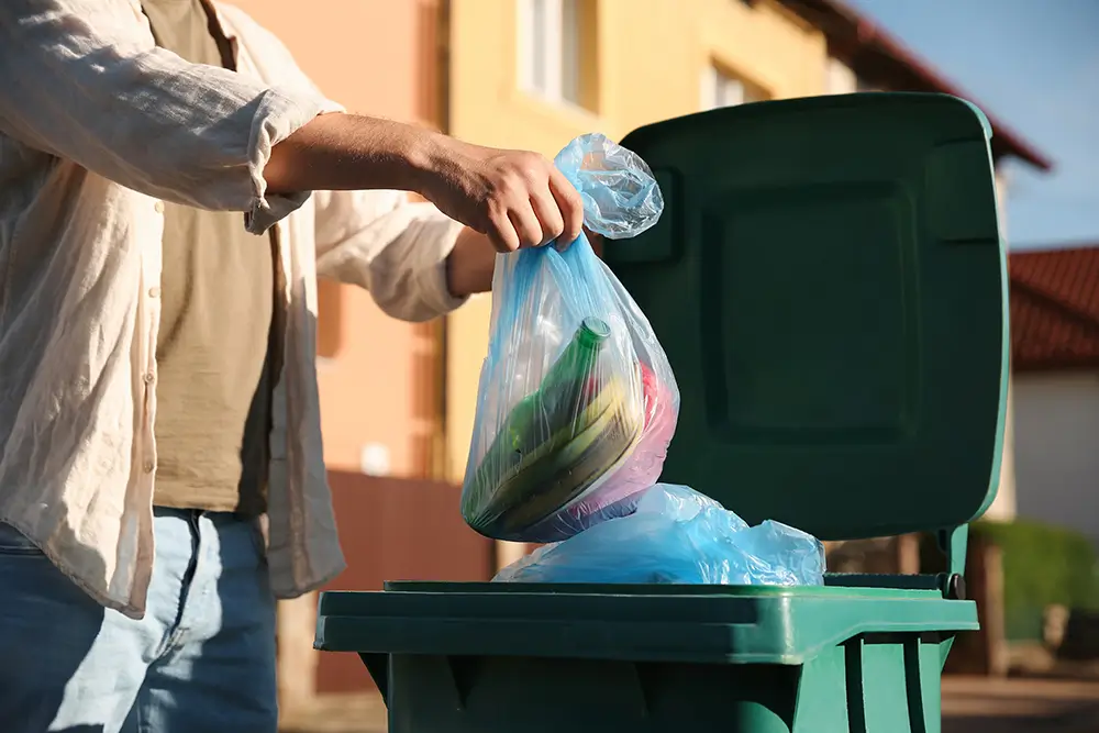 Velká část odpadu, který produkujete, jde snadno vytřídit nebo dokonce zkompostovat. Zdroj: Shutterstock - SportDeník muž vhazuje odpad do popelnice