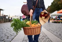 Mladá žena držící košík s farmářskými produkty