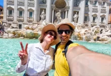 Mladý rozesmátý pár si dělá selfie před slavnou Fontánou di Trevi v Římě