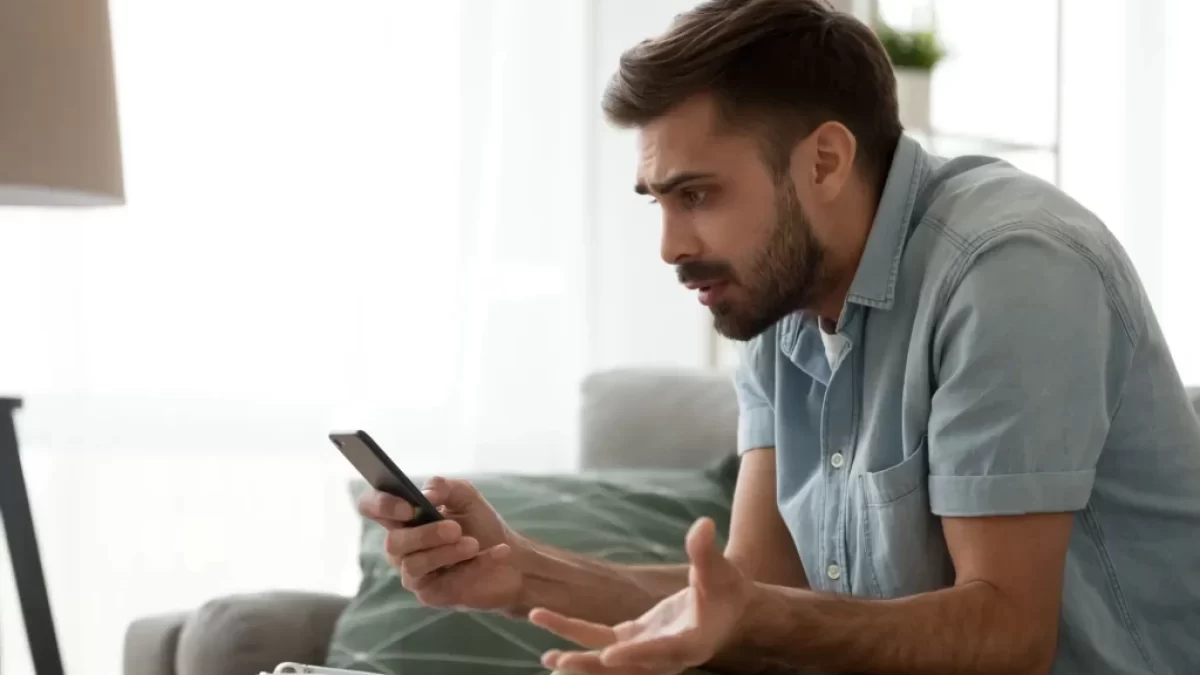 muž drží v ruce telefon