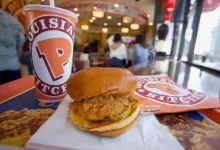 Kuřecí hamburger s nápojem na stole v restauraci