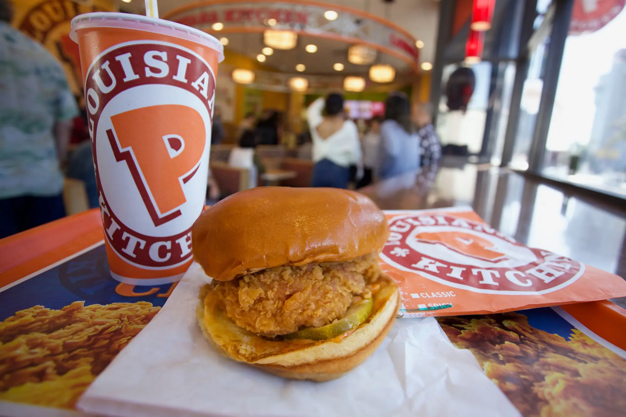 Kuřecí hamburger s nápojem na stole v restauraci