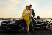 Bohatý mladý pár stojící u luxusního auta