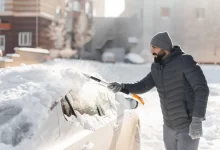 Muž škrábe auto.