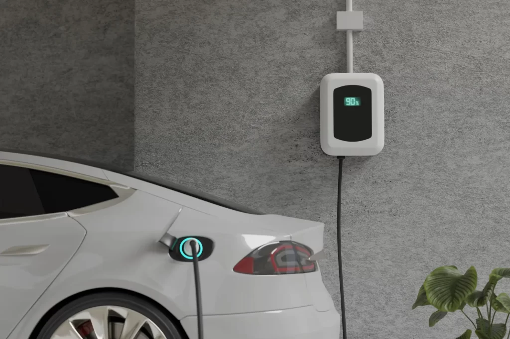 Bílý elektromobil zapojený do nabíjecí stanice