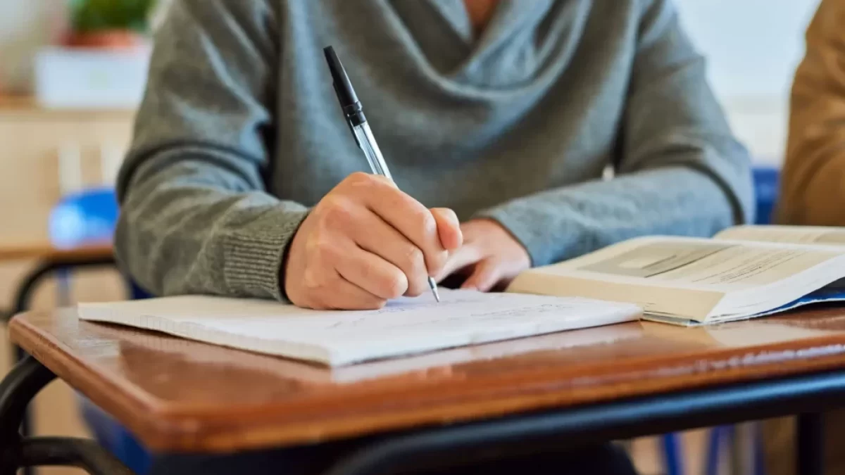 Student zapisující si poznámky do sešitu