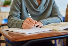 Student zapisující si poznámky do sešitu