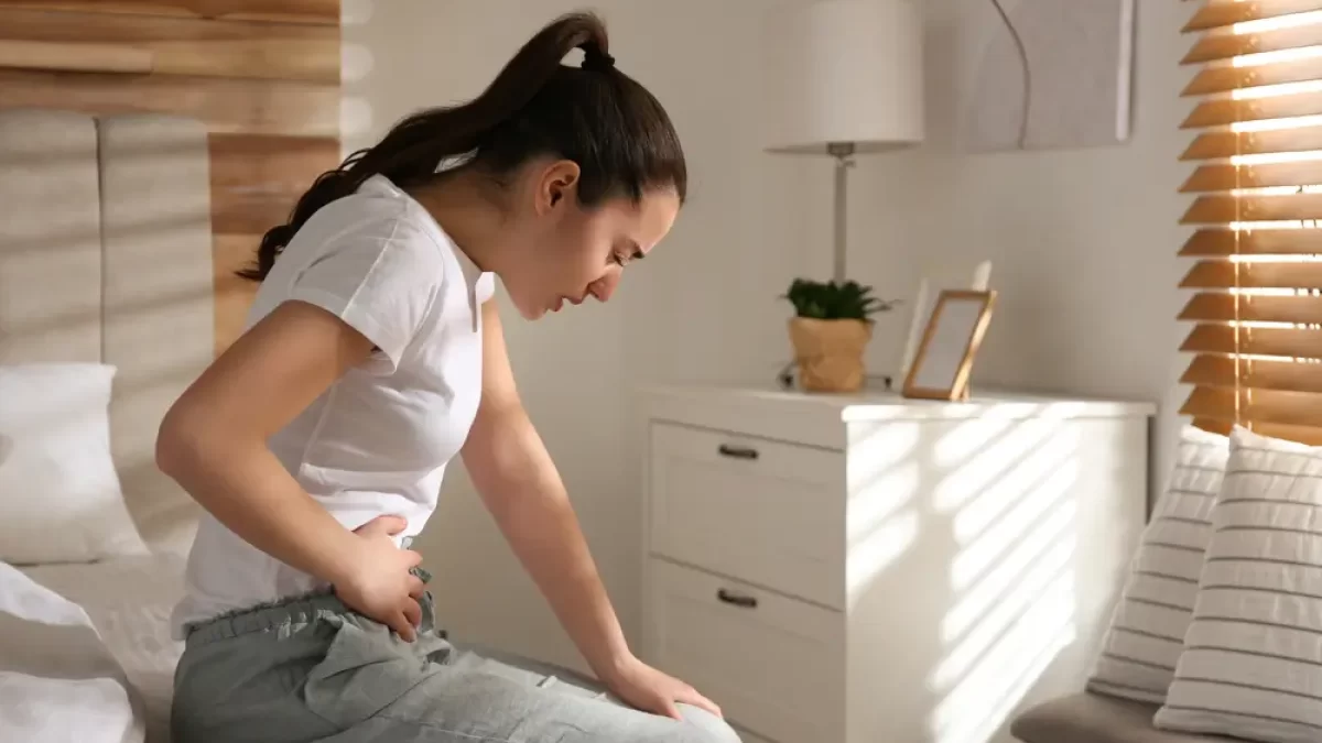 žena sedící na posteli se zdravotními problémy