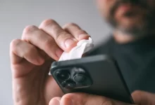 muž čistí telefon