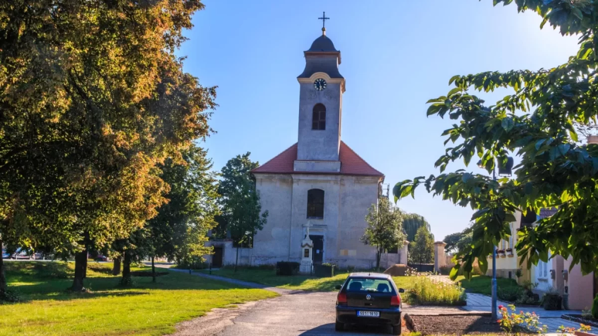 Kostel na návsi obklopený stromy