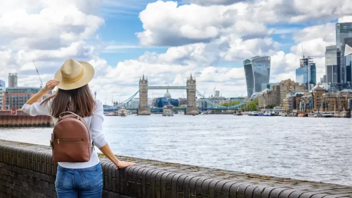Mladá dívka s batůžkem na zádech si prohlíží London Bridge
