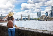 Mladá dívka s batůžkem na zádech si prohlíží London Bridge