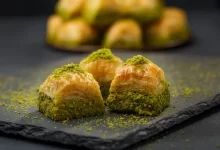 Tři kousky baklavy na černém tácu