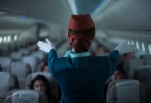 Letuška ukazující pasažérům letové pokyny
