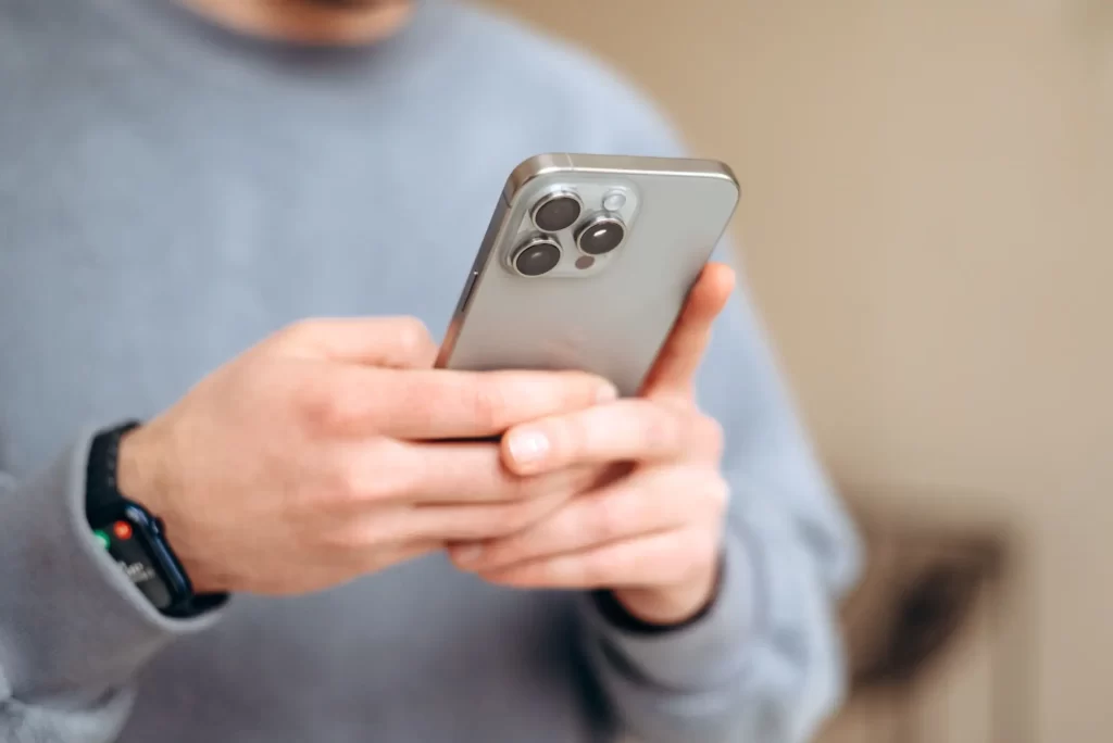 Apple Intelligence pomůže například při psaní zpráv, FOTO: Shutterstock - SportDeník muž drží iphone