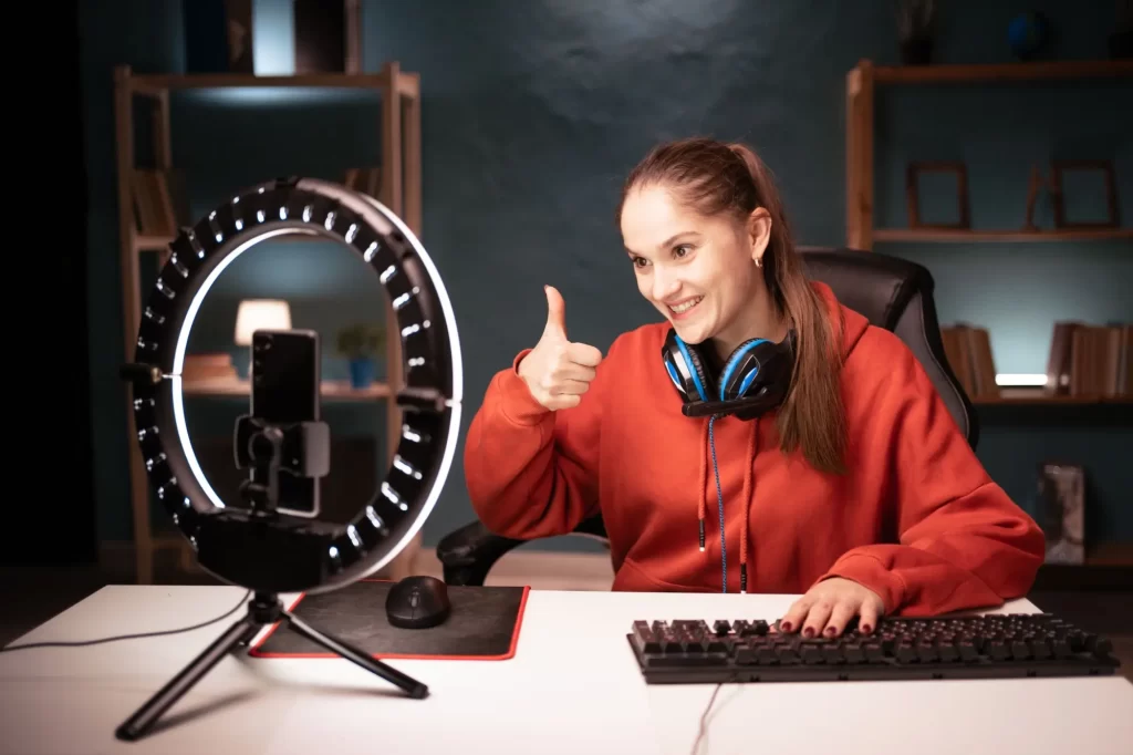 Mladá streamerka nahrávající ve studiu video na mobil