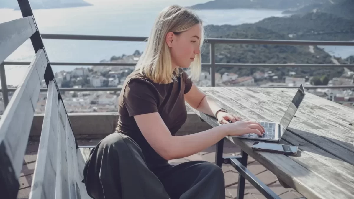 Žena pracuje u moře na notebooku