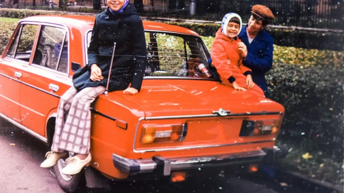 Stará fotografie otce s dětmi u starého červeného auta