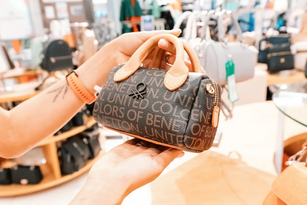 Benetton 1 - SportDeník Ženská ruka držící kabelku italské módní značky Benetton