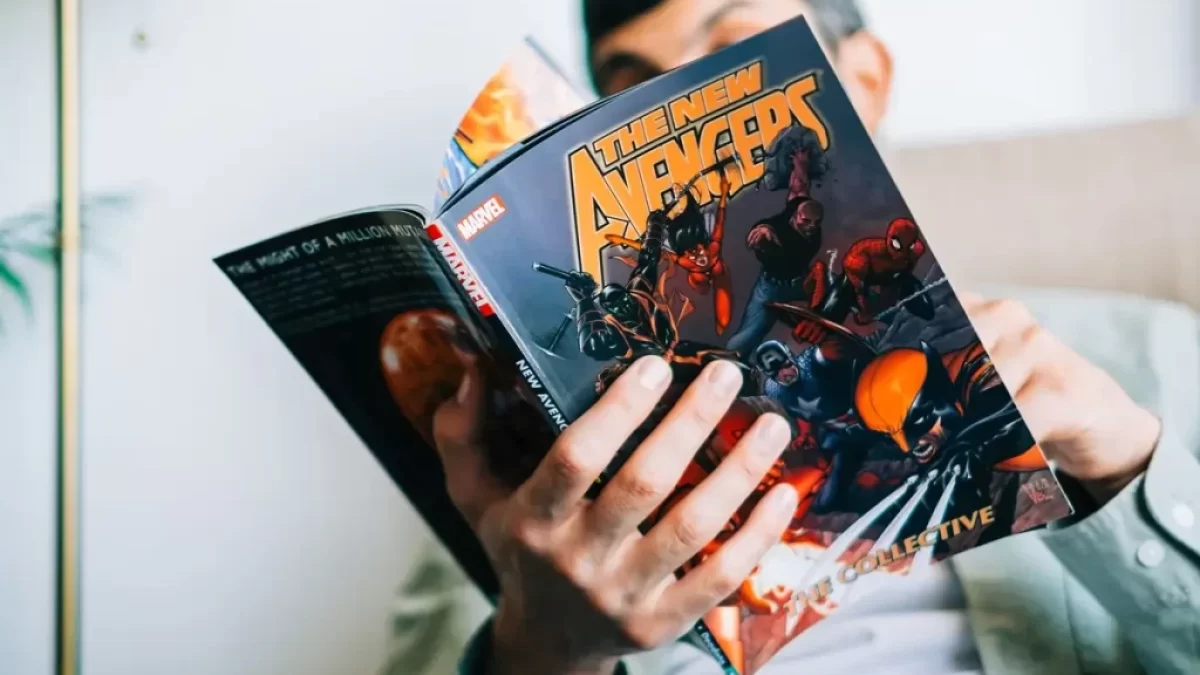Muž drží v ruce komiks a čte si