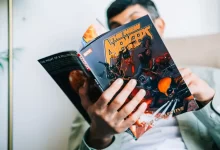 Muž drží v ruce komiks a čte si