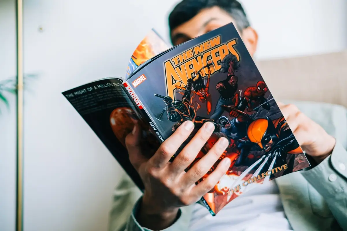 Muž drží v ruce komiks a čte si