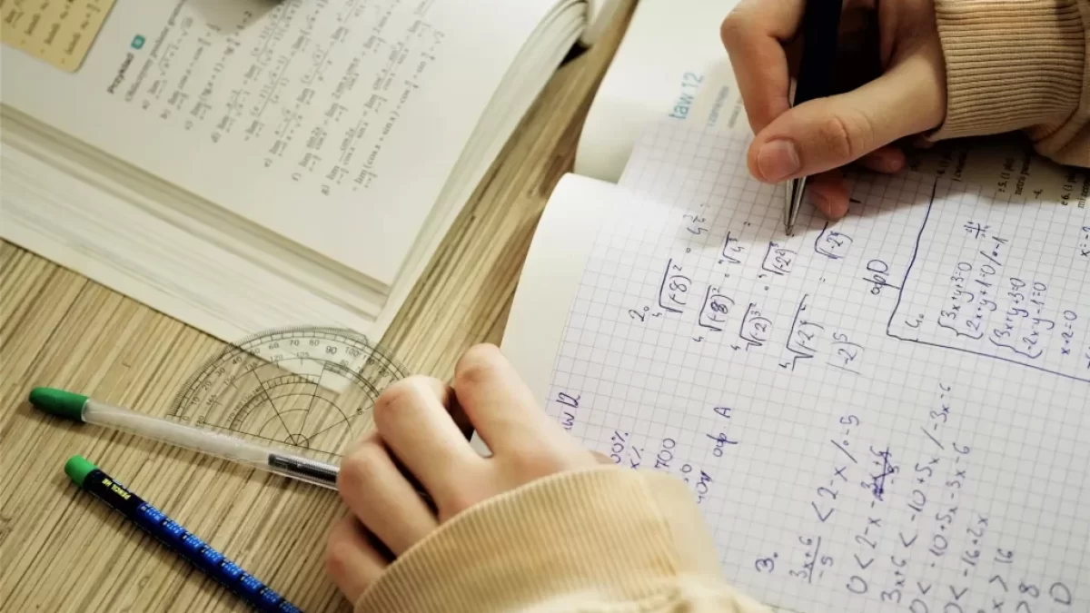Studentka počítá příklad z matematiky do sešitu