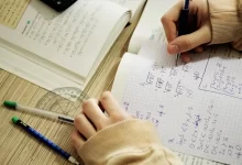 Studentka počítá příklad z matematiky do sešitu