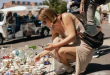 Žena středního věku prohlížící staré nádobí na bleším trhu